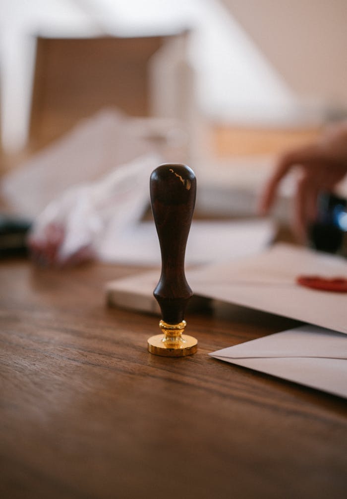 about-01 A close-up of a vintage wax seal stamp on a wooden desk with envelopes, conveying an old-world charm.